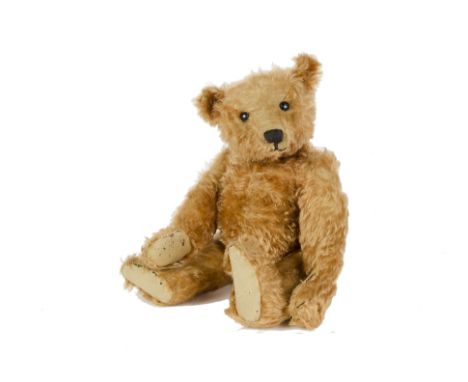 An early Steiff apricot mohair Teddy Bear, circa 1908, with boot button eyes, pronounced clipped muzzle, black stitched nose,