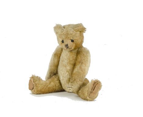 A fine and early British Teddy Bear, 1910-1920s, with pale golden mohair, boot button eyes, pronounced clipped muzzle, black 