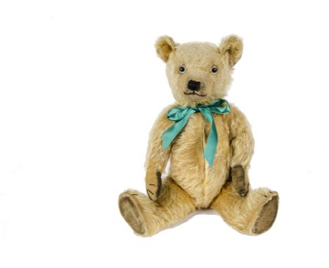 A 1930s Chiltern Teddy Bear, with golden mohair, replaced glass eyes, pronounced muzzle, black stitched nose, mouth and claws