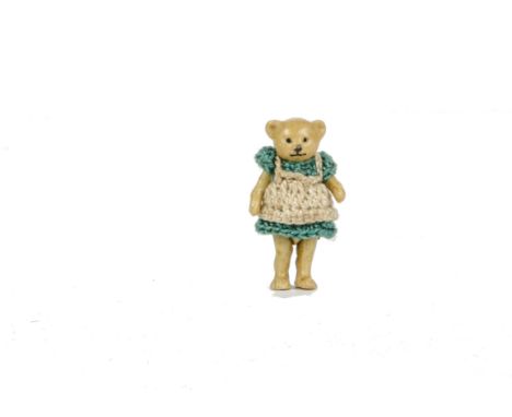 A Hertwig all - bisque girl Teddy Bear, 1910-20s, with pin - joints and green crochet dress - 1¾in. (4.5cm.) high