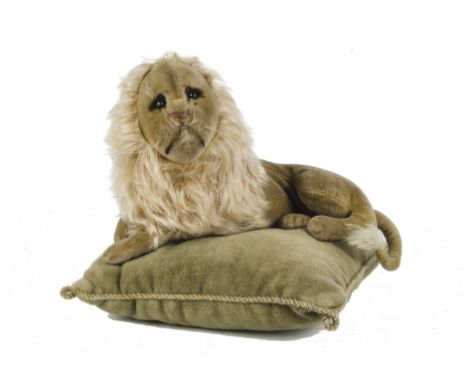 A rare and early Steiff lying velvet lion, with black boot button eyes, black shading behind eyes, painted features, whiskers