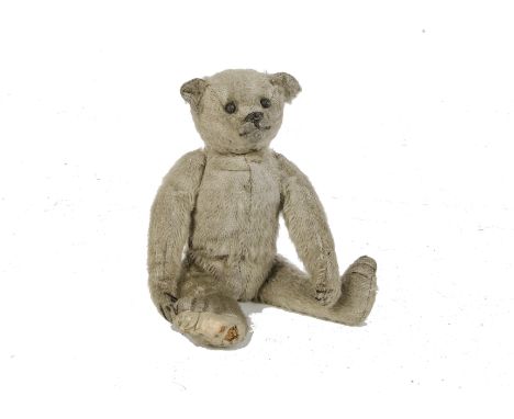 An early British Teddy Bear, 1920s, with white mohair, black boot button eyes, pronounced muzzle, black stitched nose, mouth 