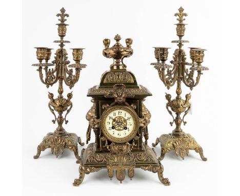 A three-piece mantle garniture clock and candelabra, made of bronze. The first half of the 20th century. Height of candelabra