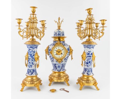 A three-piece mantle clock with candelabra made of Delft's porcelain mounted with bronze. The first half of the 20th century.