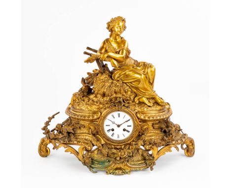 A mantle clock 'The Harvest' with an image of a resting lady with a dove, on top of the harvested wheat. Made of gilt bronze,