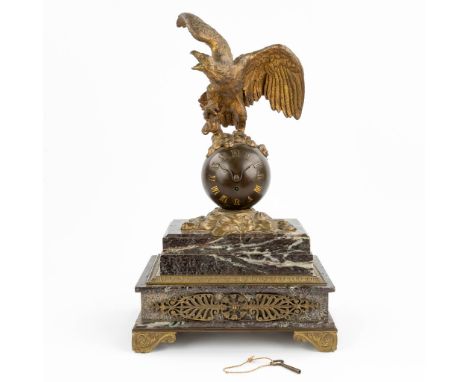 AÊmantle clock made of marble mounted with patinated bronze in empire style and decorated with an eagle. The dial consists of