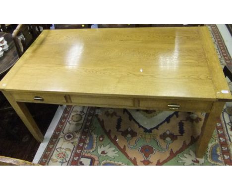 A modern light oak farmhouse kitchen table with two frieze drawers, on square tapering legs