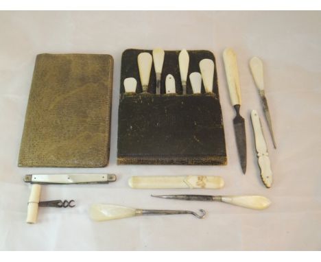 An Edwardian lizard skin covered ladies wallet and a leather pouch containing various manicure items with bone / ivory / moth