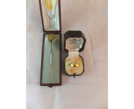 A 22 carat gold wedding band, 9.4 g and a gold coloured and enamel decorated stock pin 