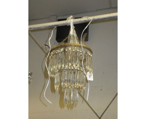 A three tier glass drop and brass mounted ceiling light shade