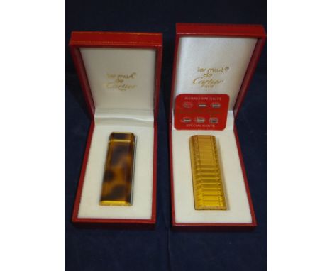 A Les Must de Cartier gold plated cigarette lighter and a Les Must de Cartier simulated tortoiseshell cased cigarette lighter