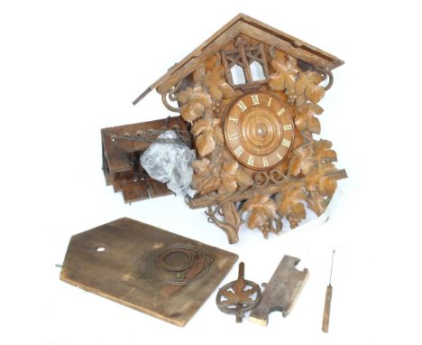 Black Forest two train cuckoo clock in need of restoration, the 6.25" dial within a chalet case carved overall with fruiting 