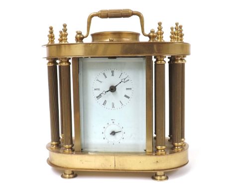 Brass cased two train alarm mantel clock striking on a bell, within a pillared case with rounded ends surmounted by a carryin