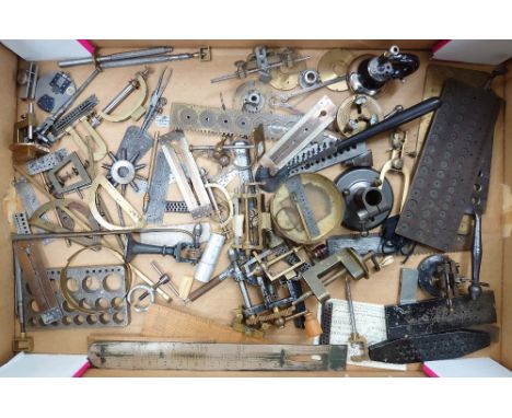 Interesting assortment of small mainly brass and steel clock tools, including mainspring winders, clamps, screw plates and me