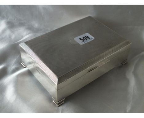 Cigarette box with engine turned cover, raised on bracket feet, 6.5" wide