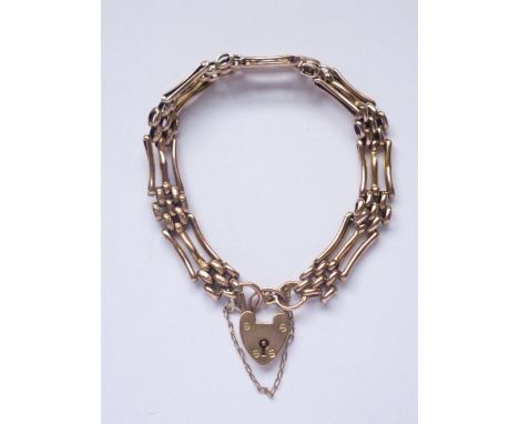 A rose coloured yellow-metal (tested as gold) gate-link bracelet, with polished and textured links, and a heart-shaped padloc