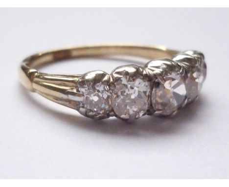 An antique five-stone diamond ring, the Old European Cut diamonds being rub and claw set in a graded arrangement, the largest