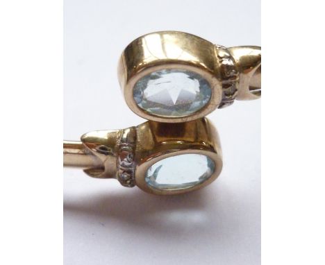 A 9ct gold, aquamarine and diamond bangle, of torque form, terminating in oval-cut aquamarines of approximately .75ct, 7.2g