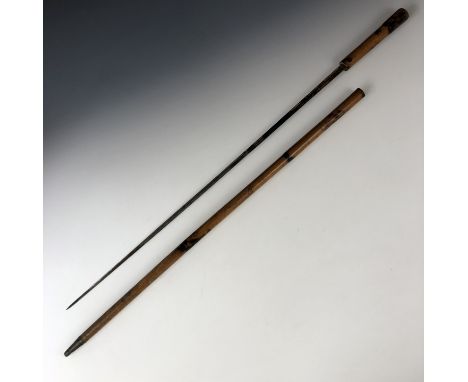 A 19th century turned and scorched beech faux-bamboo sword stick, concealing a single edged and fullered blue-and-gilt blade,