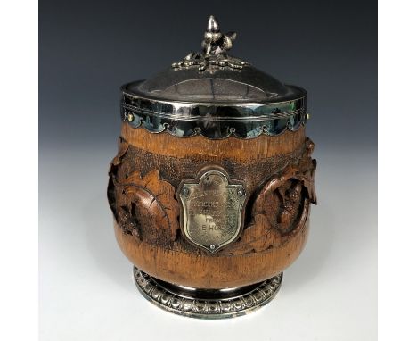 A carved oak and electroplate mounted tobacco jar bearing a plaque with engraved inscription "Presented to the Officers Mess,
