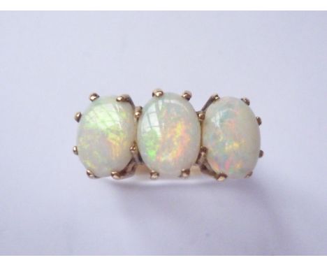 A three-stone opal dress ring, each cabochon of approximately .78ct, crown-held above a 9ct gold shank