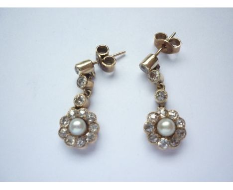 A pair of antique diamond and pearl ear pendants, each comprising three brilliant-cut and millegrain set diamonds, individual