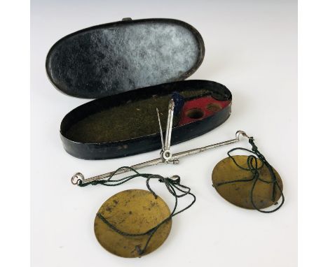 A Georgian set of pocket steel and brass coin / sovereign scales, within a Japanned oval case