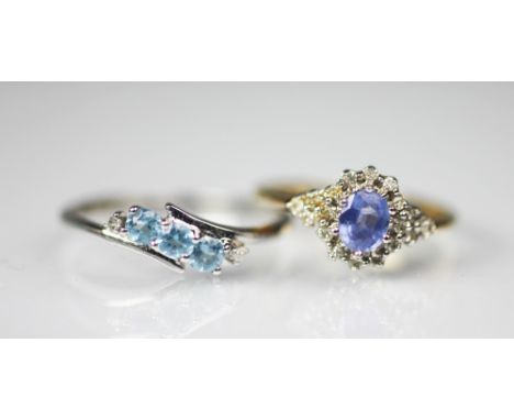 A tanzanite and diamond ring, the central oval tanzanite, with a diamond set surround, all set in white metal to the 9ct yell