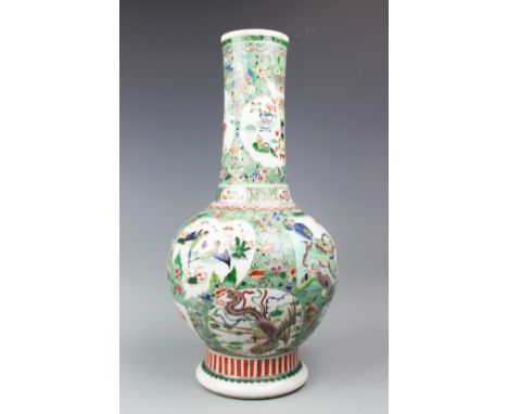 An early 19th century Chinese porcelain famille verte bottle vase, decorated to the bulbous body with four panels depicting a