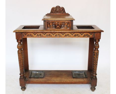 A Victorian carved oak umbrella stand, with drawer and green man handle, above a shelf and on carved legs, 96cm H x 91cm W x 