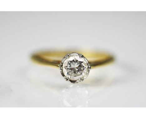 A diamond solitaire ring, the round brilliant cut diamond within white metal setting, tapering shoulders and plain 18ct yello