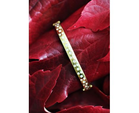An 18ct yellow gold diamond set bangle, the hinged bangle set to either side with brilliant cut diamonds, the integral clasp 