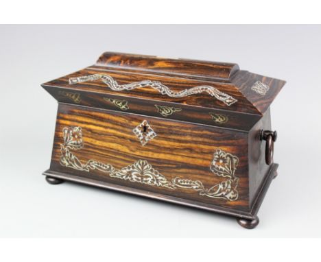 A 19th century mother of pearl inlaid Coromandel wood tea caddy, of sarcophagus form, with associated mixing bowl and two int