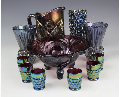 A selection of blue and purple carnival glass wares including, a purple tripod bowl upon three dolphin feet, 21cm diameter, a