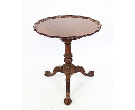 A George III style mahogany tilt top occasional table, with pie crust edge, on a turned column and tripod base with pad feet,