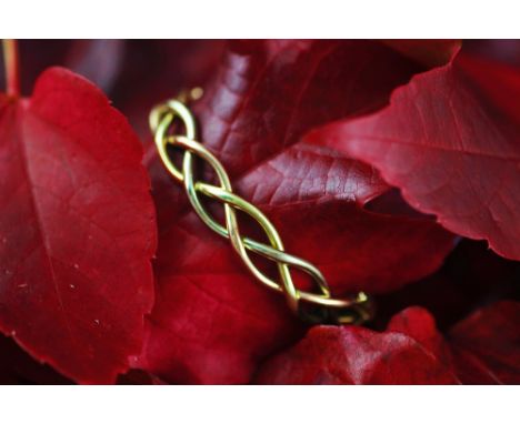 A tri-colour gold hinged bangle, of woven form, integral clasp with double safety catches, stamped '375', weight 19.5gms 