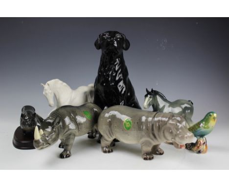 A large Royal Doulton 2341 black Labrador, 33cm high, along with a Melba Ware hippo, rhino and horse, a Beswick Spirit of Fre