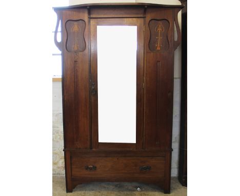 An Arts and Crafts inlaid oak wardrobe, with mirrored door above a long drawer, on bracket feet, 201cm H x 130cm W