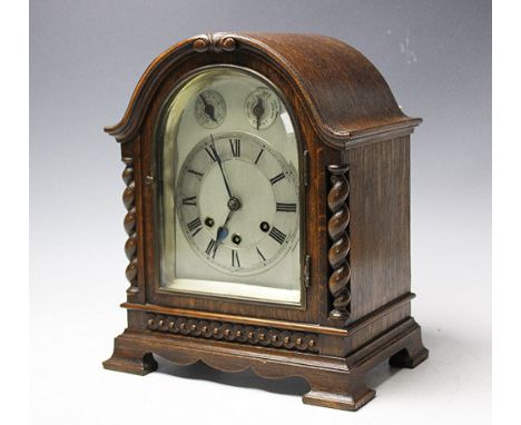 A 1920'S oak eight day mantel clock, with silvered Roman numeral chapter ring below two selector dials, with movement strikin