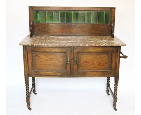 An Edwardian oak wash stand, with green tile back and marble top, above two doors, on turned legs, 112cm H x 107cm W x 48cm D