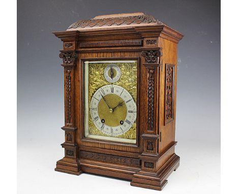 A late Victorian eight day carved oak mantle clock, the silvered Roman numeral dial above a regulator dial and movement strik