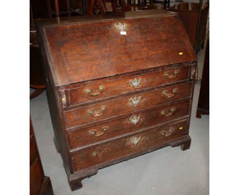 A late 18th century/early 19th century oak fall front bureau, fitted four drawers with swing brass handles, on shaped bracket