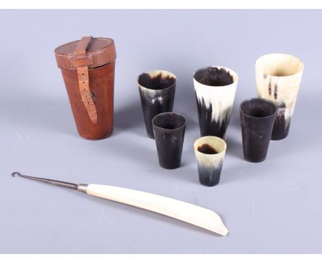 A late 19th century graduated set of horn hunting beakers, in leather case, together with an ivory and white metal boot hook