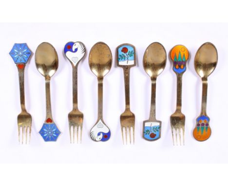 A set of four Danish silver gilt and enamel commemorative spoons and forks by Anton Michelsen, each finial of differing desig