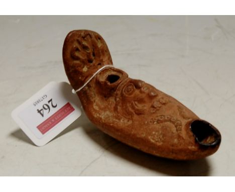 A Byzantine style pottery oil lamp of slipper form and embossed with a mask, probably 19th century