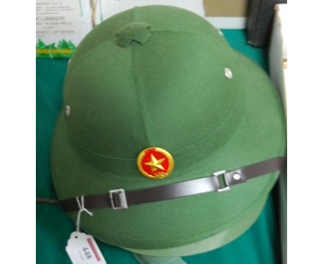 A reproduction North Vietnamese pith helmet; and one other (2) 