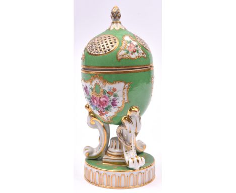 A Egg-shaped porcelain pomander, with floral decorations on a green base. Hinged lid with pierced panels. Marked 'D' to base 