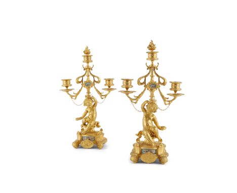 A PAIR OF 19TH CENTURY ORMOLU FIGURAL CANDELABRA, inset with small oval Sèvres style porcelain plaques, the putti figure hold