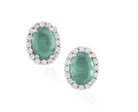 A PAIR OF EMERALD AND DIAMOND EARSTUDS, each oval-shaped emerald weighing approximately 0.45ct each, within a surround of bri