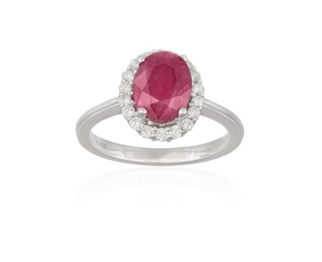 A RUBY AND DIAMOND DRESS RING, the oval-shaped ruby weighing approximately 2.20cts, within a surround of brilliant-cut diamon